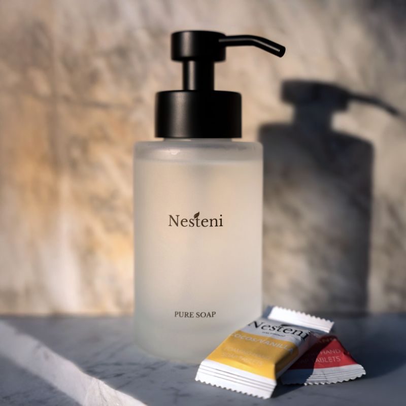 Frostat glaspump och tvåltabletter från Nesteni på marmoryta.