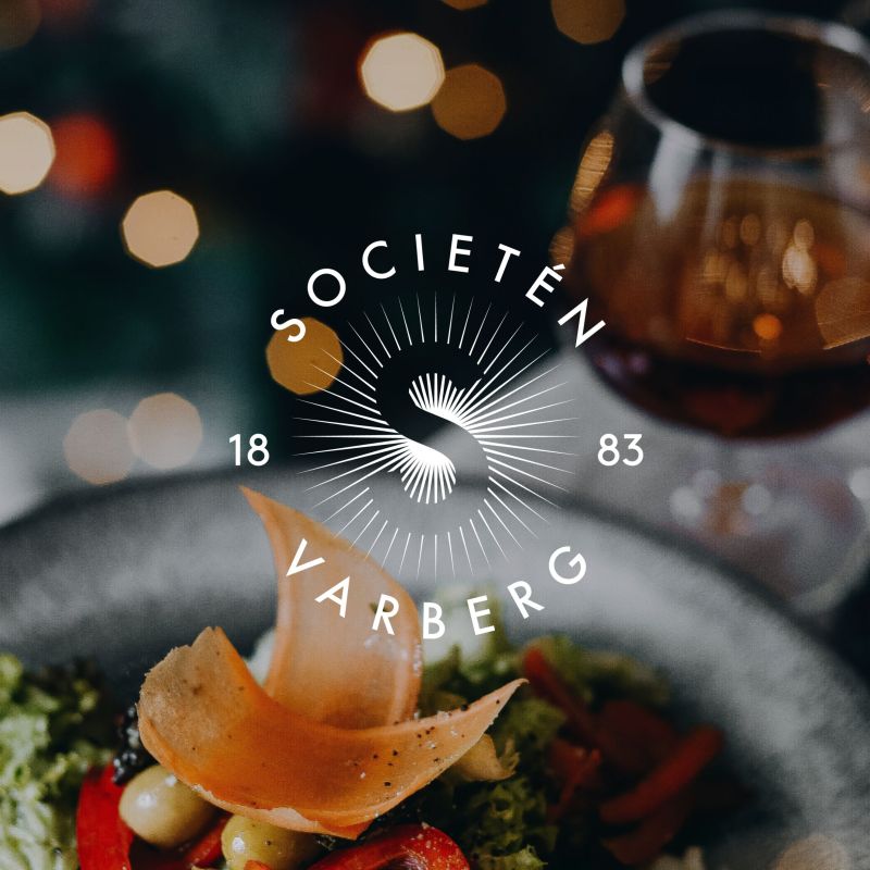  Societéns logotyp placerad över en stämningsfull bild på mat och dryck, vilket representerar restaurangverksamheten i Varberg.