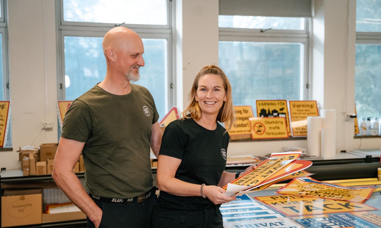 Personal hos Happy Print visar upp ett brett utbud av egentillverkade skyltar i sin verkstad.