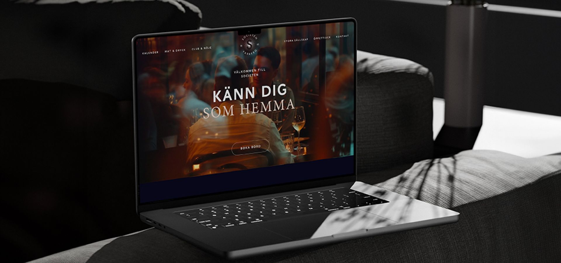  Societéns nya hemsida visas på en laptop med en stämningsfull bild och texten ”Känn dig som hemma”.