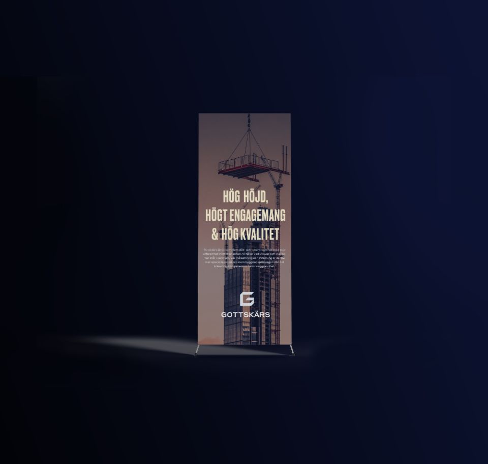 En stilren roll-up för Gottskärs med rubriken ”Hög höjd, högt engagemang & hög kvalitet” mot en bakgrund av en hög byggnad och en lyftkran. Designen förstärker företagets professionella profil och expertis inom tak- och plåtentreprenad.