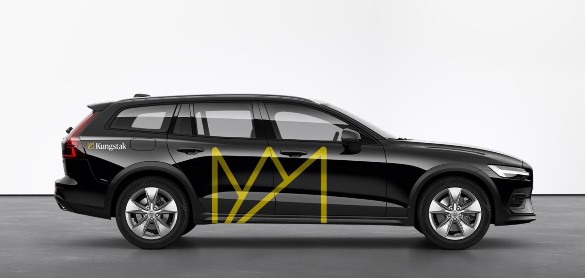  Svart tjänstebil med Kungstaks nya profilering, där en stor gul logotyp pryder dörrarna för maximal synlighet.