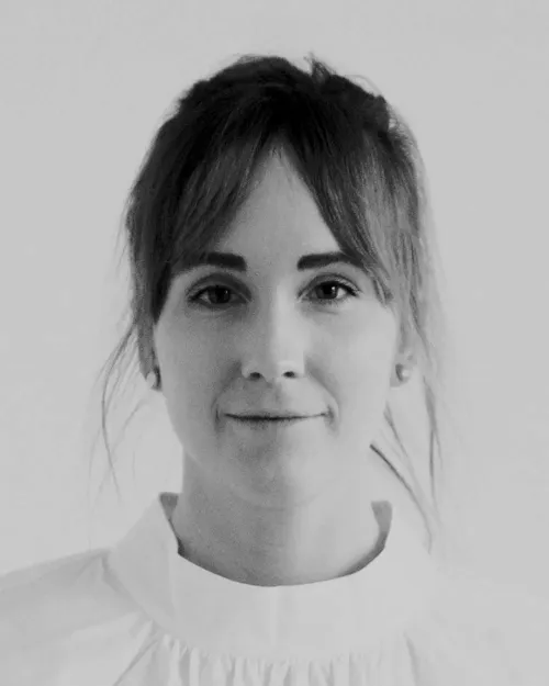 Porträtt av Johanna J Backman, Art Director och SoMe-ansvarig, med ljust hår och lugg, klädd i en vit blus.