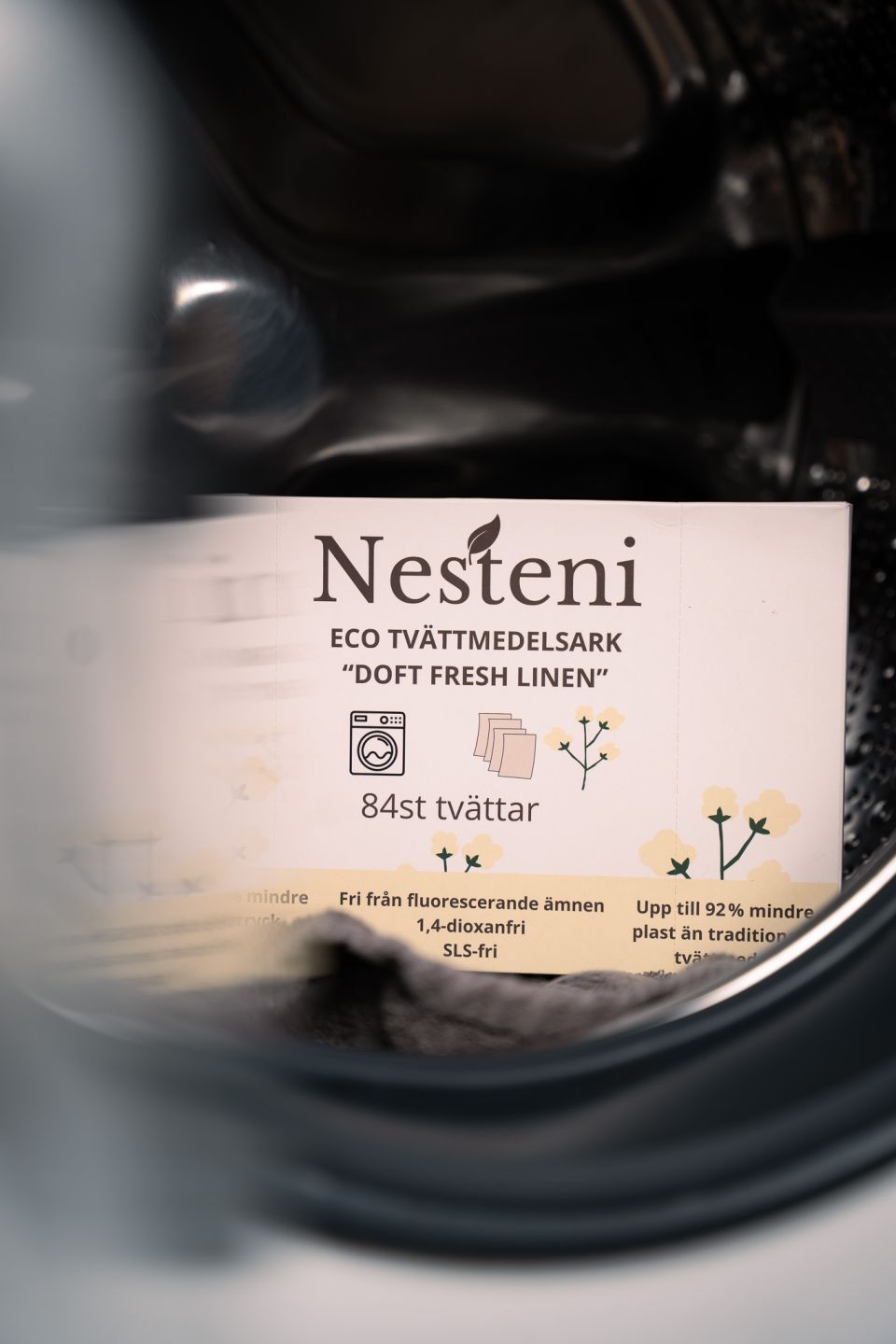 Förpackning med eco tvättmedelsark från Nesteni placerad i en tvättmaskin.