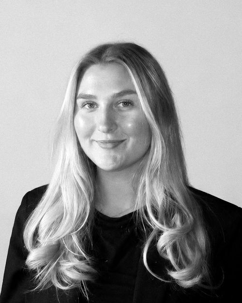 Porträtt av Linn Gustavsson Social Media-ansvarig, med långt hår, iklädd en svart kavaj