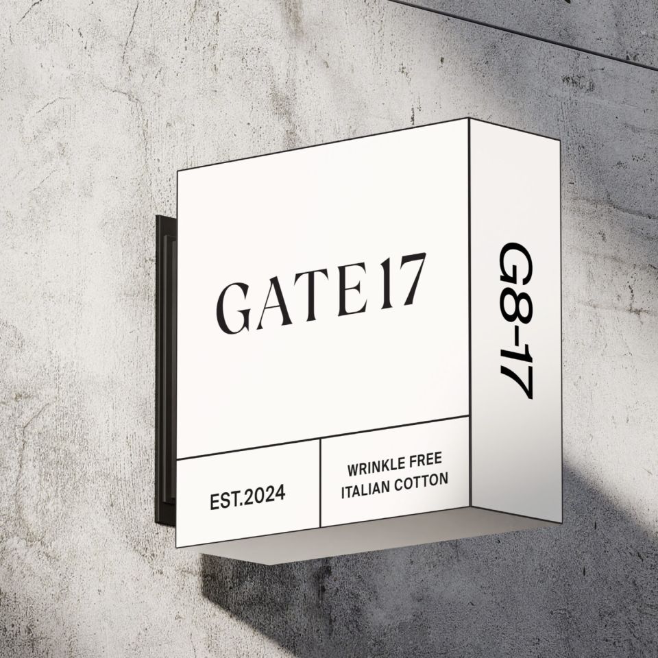 Fasadskylt för Gate 17 i en minimalistisk, reseinspirerad design med texten ”Wrinkle free Italian cotton”.