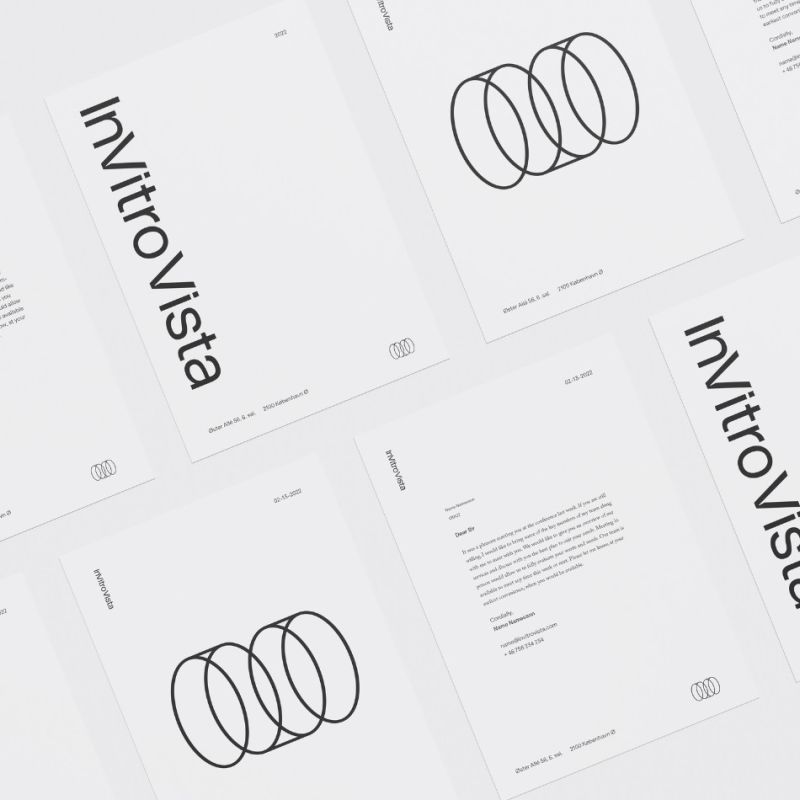 En översikt av InVitro Vistas brevpapper och korrespondensmaterial. Designen är strikt minimalistisk med svart linjegrafik som visar företagets namn och den cirkelformade symbolen på vita ark.