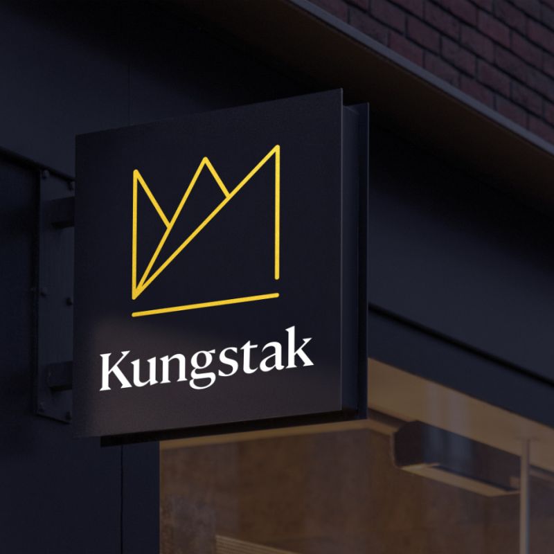  Fasadskylt för Kungstak i svart utförande med den nya gula logotypen, som förmedlar en modern och professionell känsla.