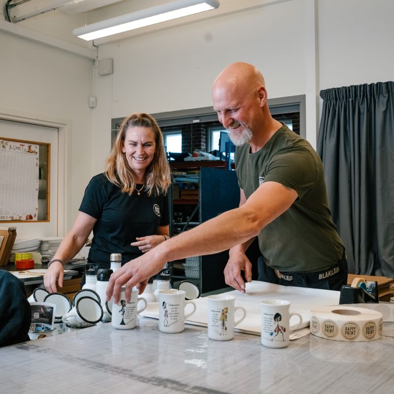 Personal och medarbetare packar muggar med tryck hos Happy Print.