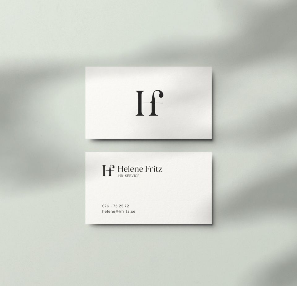 Fram- och baksida av minimalistiska visitkort för Helene Fritz HR-Service. De visar en elegant svart logotyp och kontaktuppgifter mot en ren, vit bakgrund med mjuka skuggspel.